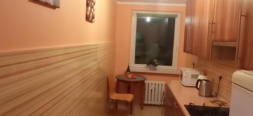 cocina con suelo de madera y ventana en Apartament 2 pokoje w centrum Opola en Opole