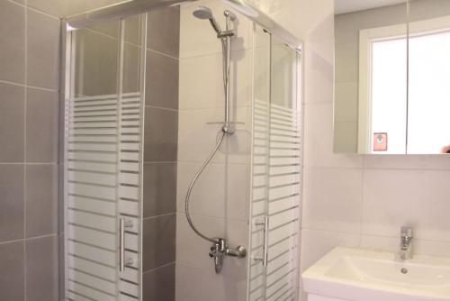 ein Bad mit einer Dusche und einem Waschbecken in der Unterkunft Modern 3 Bed 3 Bath Apt w Sea View in Beirut