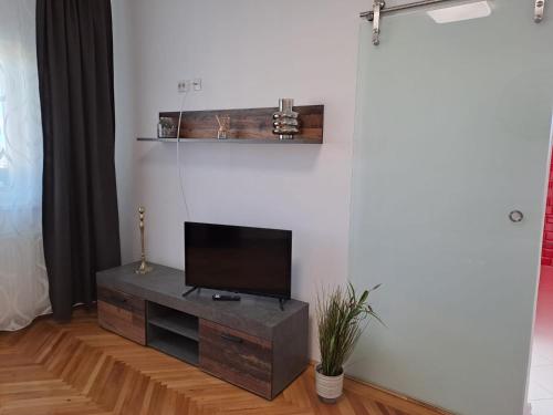 een woonkamer met een flatscreen-tv op een kast bij Rosso Apartment in Braşov