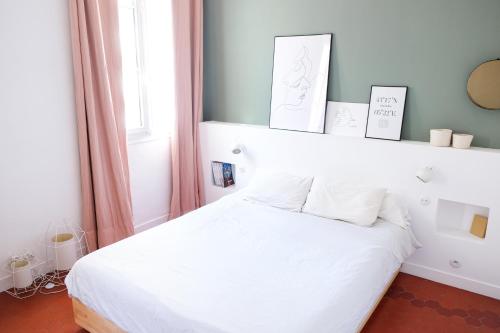 a bedroom with a white bed with white pillows at MaïHomes - La Villa Marseillaise in Marseille