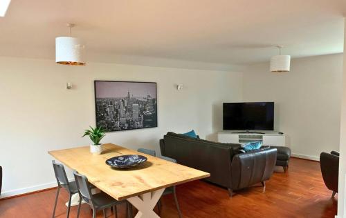 sala de estar con mesa, sillas y TV en Wokingham - Large 2 bedroom Apartment en Wokingham