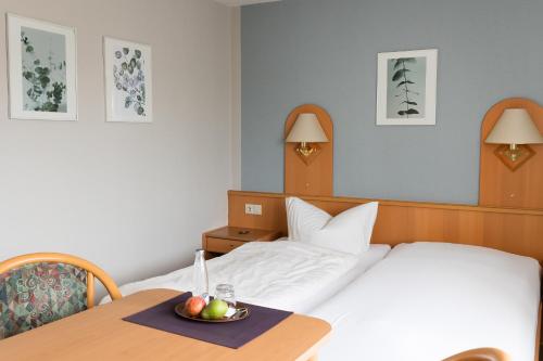 a hotel room with a bed and a bowl of fruit on a table at Pension Ridder in Marienmünster