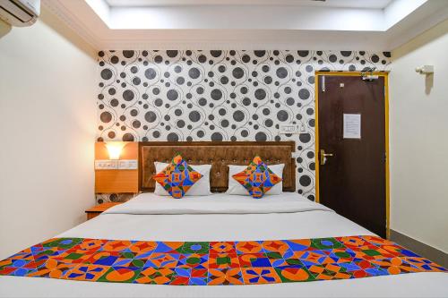 um quarto com uma cama com um edredão colorido em FabHotel Sagar Royale em Bhubaneshwar