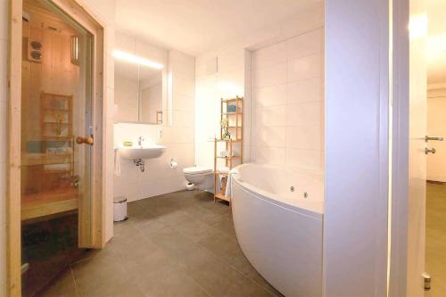 a bathroom with a tub and a toilet and a sink at Apartmenthaus Scharmützelsee inkl Nebenkosten in Wendisch Rietz