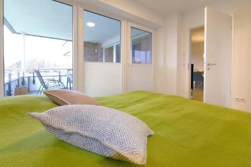a bedroom with a green bed with two pillows on it at Apartmenthaus Scharmützelsee inkl Nebenkosten in Wendisch Rietz