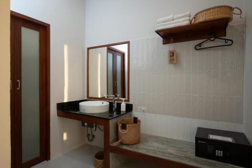a bathroom with a sink and a mirror at Ploen Pirom in Lat Krabang