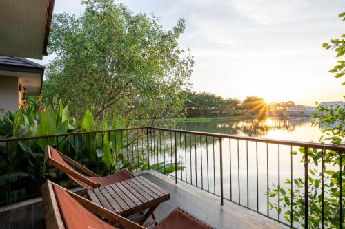 a balcony with two chairs and a view of a river at Ploen Pirom in Lat Krabang