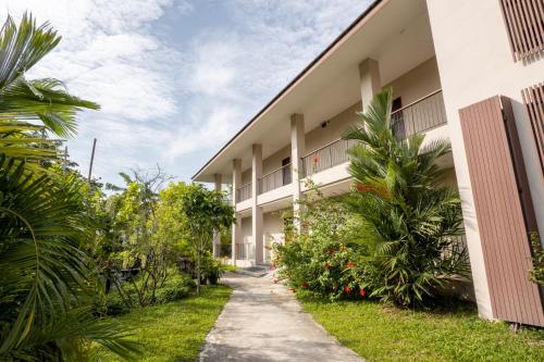 a building with plants and a sidewalk at Ploen Pirom in Lat Krabang