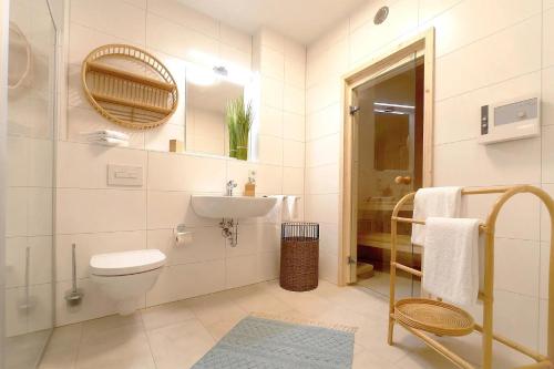 a white bathroom with a sink and a toilet at Apartmenthaus Scharmützelsee inkl Nebenkosten in Wendisch Rietz