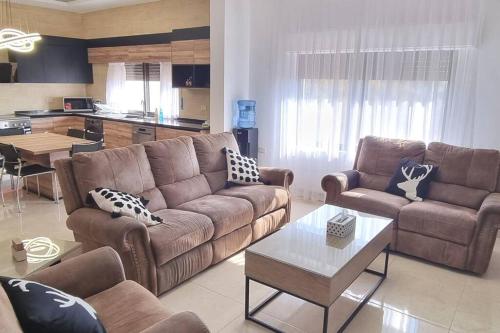 uma sala de estar com um sofá e uma mesa em 3 Bedroom mountain view apartment overlooking Al Fuhais em Amã