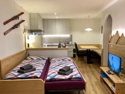 a small room with a bed in the middle of a kitchen at Casa Volcan in Tesero