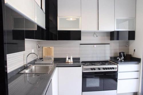 a white kitchen with a sink and a stove at Modern 3BR Apt next to Hotel Dieu in Beirut