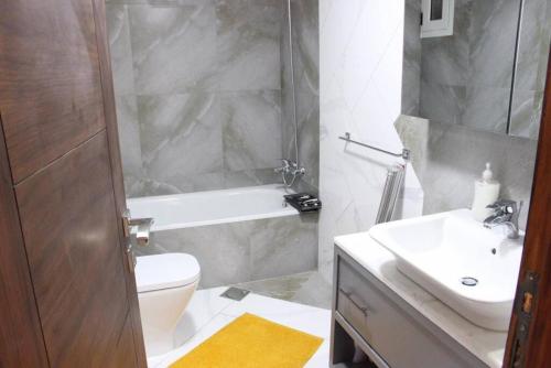 een badkamer met een wit toilet en een wastafel bij Modern 3BR Apt next to Hotel Dieu in Beiroet