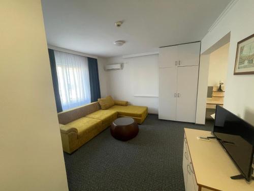 uma sala de estar com um sofá e uma televisão em Hotel Ada - Otoka em Saraievo