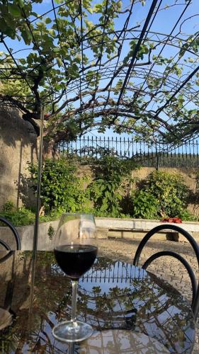 a glass of wine sitting on a table at Porto Area, Poolside Sunsets of Vila Boa in Vilarinho