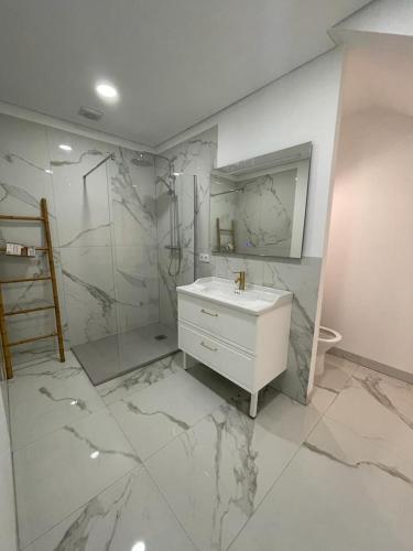 a white bathroom with a sink and a shower at Porto Area, Poolside Sunsets of Vila Boa in Vilarinho