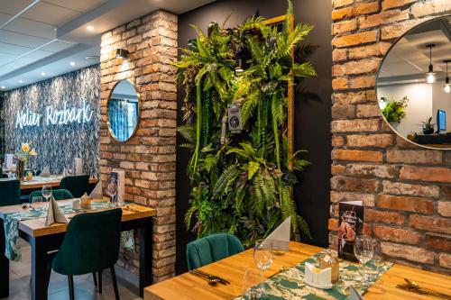 restauracja z drewnianymi stołami i roślinami na ścianie w obiekcie Seven Hotel Bytom - Katowice w Bytomiu