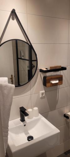 ein Badezimmer mit einem weißen Waschbecken und einem Spiegel in der Unterkunft Kreuzblume Hotel & Weinstube in Freiburg im Breisgau