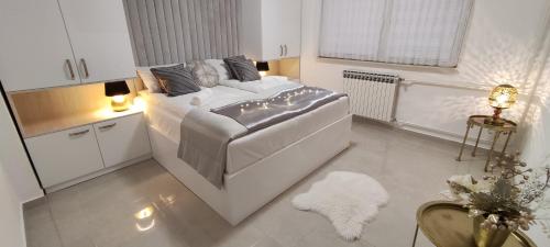 1 dormitorio con 1 cama blanca y cocina blanca en Vila Džan, en Sarajevo