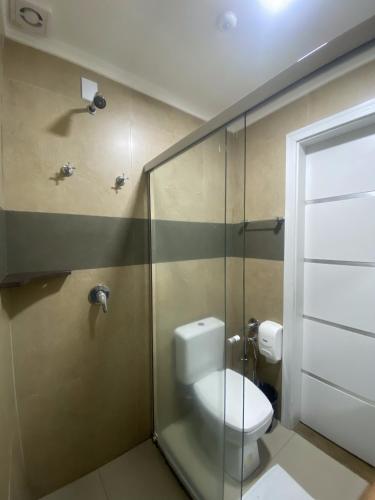 a bathroom with a toilet and a glass shower at Hotel Maravilha in Caçapava do Sul