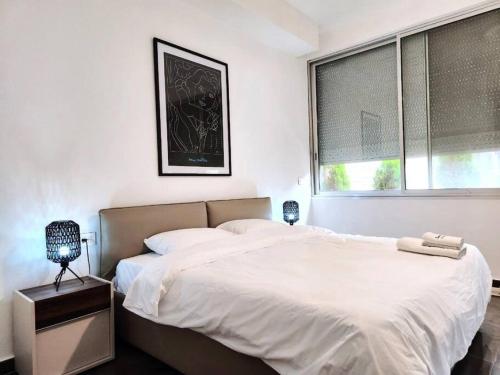 Un dormitorio blanco con una cama grande y una ventana en Chic Contemporary 3BR in Mar Mikhael, en Beirut