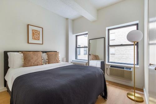 a bedroom with a large bed and two windows at Hudson Yards 1br w gym wd nr penn station NYC-1308 in New York