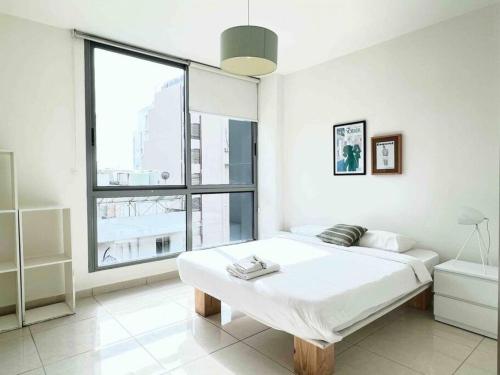 um quarto branco com uma cama e uma grande janela em Modern 3BR Apt next to Hotel Dieu em Beirute