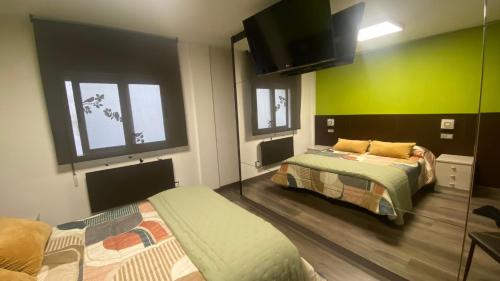2 camas en una habitación con paredes verdes en Completo apartamento para 2 en el centro de Gijón, en Gijón