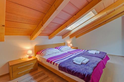 una camera da letto con un letto e due asciugamani di House MIRABELLE with Pool a Nerezine (Neresine)