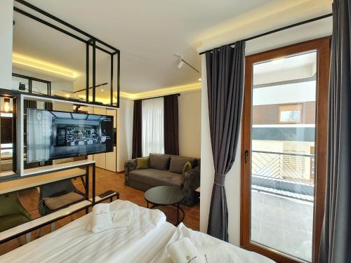una camera d'albergo con letto e soggiorno di Velika Recepcija CC Magnet a Zlatibor