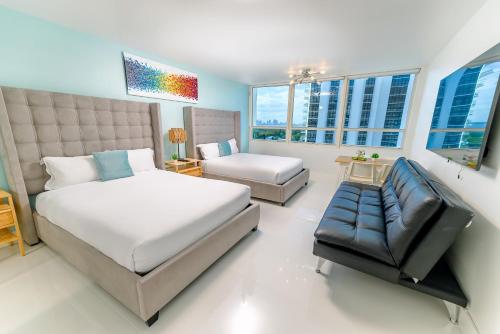 1 dormitorio con cama, sofá y ventanas en SeaStays Apartments en Miami Beach