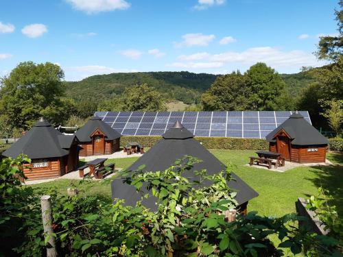 eine Gruppe von Holzgebäuden mit Sonnenkollektoren in der Unterkunft Camping Officiel Wollefsschlucht Echternach in Echternach