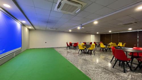 a room with a table and chairs and a green floor at BluO 1BHK Suite - Balcony, Lift, Gym, Parking in Gurgaon