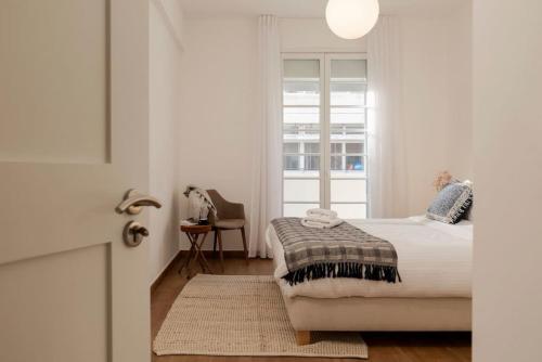 a white bedroom with a bed and a window at Stunning Artist House in Saifi in Beirut