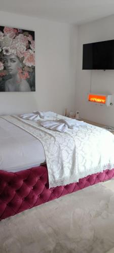 a white bed with a blanket on it in a bedroom at Sobe i apartmani Tena in Velika Gorica