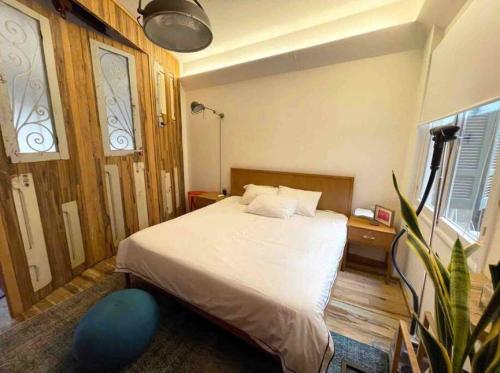 a bedroom with a bed and a plant in it at Designer 1BR apt in Gemmayze in Beirut