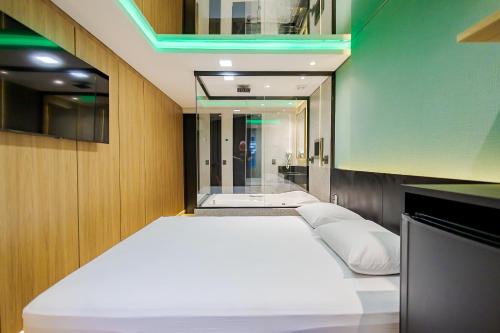 2 łóżka w pokoju z lustrem w obiekcie Drops Express Motel Curitiba w mieście Kurytyba