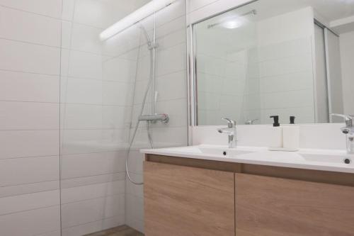 une salle de bain avec un lavabo et un miroir dans l'établissement Le Contemporain, Hypercentre Mulhouse, à Mulhouse