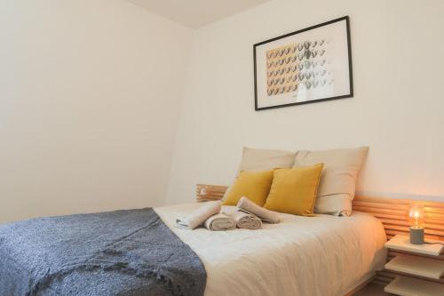 une chambre avec un lit avec deux serviettes dessus dans l'établissement Le Contemporain, Hypercentre Mulhouse, à Mulhouse