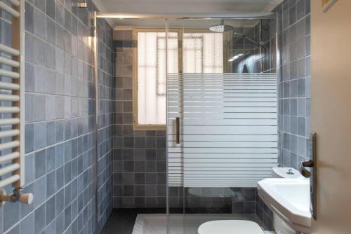 a bathroom with a shower and a toilet and a sink at Mauds Elegant Cocoon at Monot in Beirut