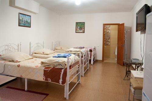 Un grupo de 4 camas en una habitación en Art Hotel Al Hayat en Kaji-Say