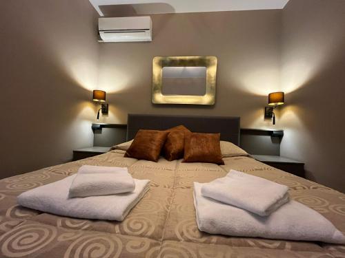 a bedroom with a bed with two pillows and a mirror at Hotel Roma in Palmanova