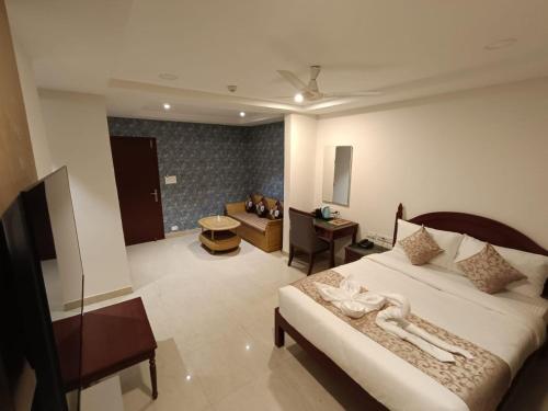 a bedroom with a bed and a living room at Hotel Monsoon Palace Guwahati in Guwahati