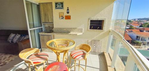 d'un balcon avec des chaises et une table. dans l'établissement Homeclub, Beto Carrero, praia, piscina diversão, à Penha