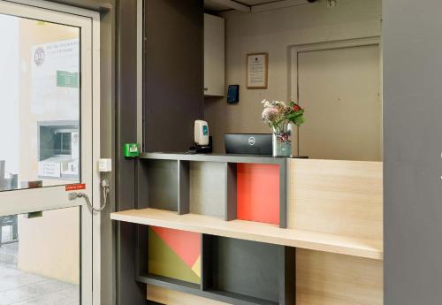 B&B HOTEL Paris Nord Villepinte في فيلبينت: مكتب به مكتب وبه لاب توب عليه