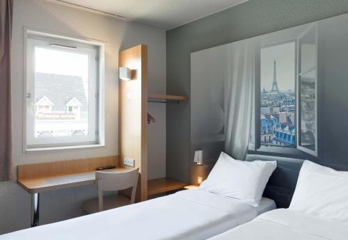 ヴィルパントにあるB&B HOTEL Paris Nord Villepinteのベッド2台と窓が備わるホテルルームです。