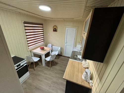 eine kleine Küche mit einem Tisch und Stühlen in einem winzigen Haus in der Unterkunft Velkom verhovina in Werchowyna