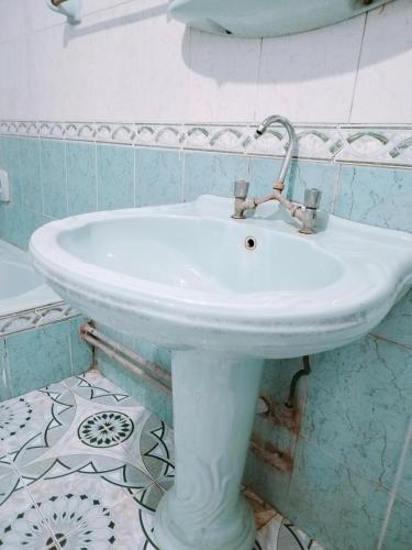 a white sink in a bathroom with blue tiles at منزل سيد سعد in Cairo