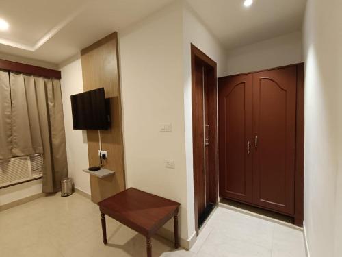 a room with a door and a bench and a tv at Hotel Monsoon Palace Guwahati in Guwahati