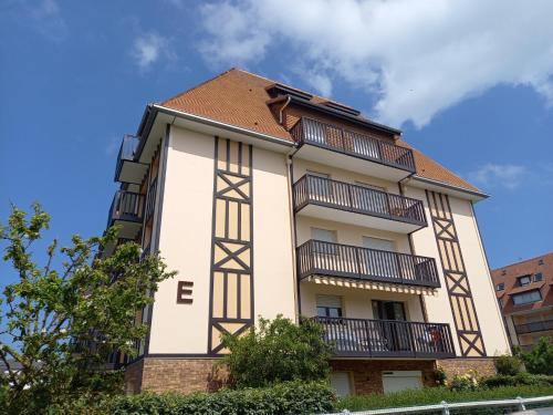 un bâtiment avec des balcons sur le côté dans l'établissement Appartement 50 m de la mer proche Deauville, à Villers-sur-Mer